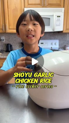 a young boy holding up a chicken rice cooker