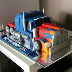 a cake shaped like a semi truck with flames on it's sides and wheels