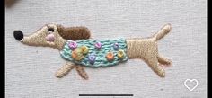 a dog is wearing a sweater with flowers on it