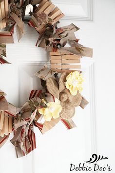 a wreath made out of books is hanging on the front door with ribbon and flowers