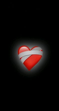 a red heart with a white strip in the middle on a black background that appears to be dark