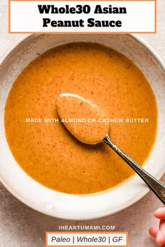 a white bowl filled with carrot soup and a spoon