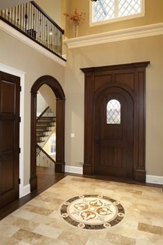 an entryway with two doors and a circular rug on the floor