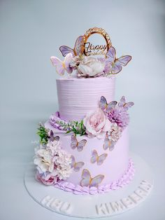 a three tiered cake decorated with flowers and butterflies