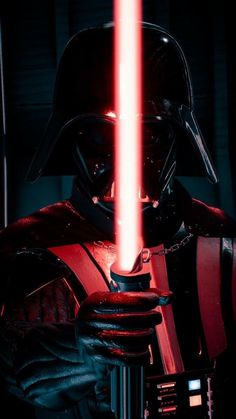 darth vader holding a light saber in his hand