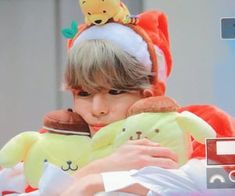 a young boy is holding two stuffed animals