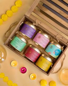 four candles are in a wooden box on a table with yellow flowers and other decorations