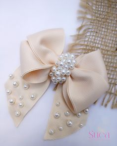 a close up of a bow with pearls on it