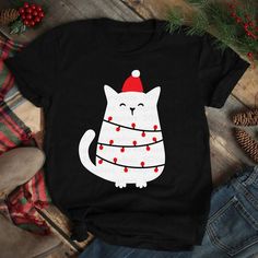 a black shirt with a white cat wearing a santa hat