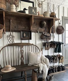 a wooden bench sitting in front of a wall filled with hats and other items on top of shelves