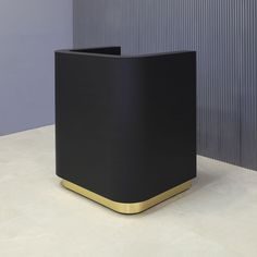 a black and gold planter sitting on top of a white floor next to a wall