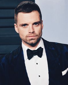 a man in a tuxedo and bow tie looking at the camera with an intense look on his face