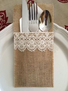 a white plate topped with a fork and knife next to a burlap napkin