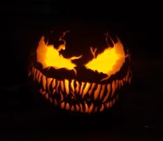 a carved pumpkin with bats on it in the dark