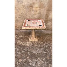 an old wooden table sitting in front of a stone wall