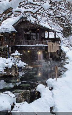 a snow covered landscape with a house and stream