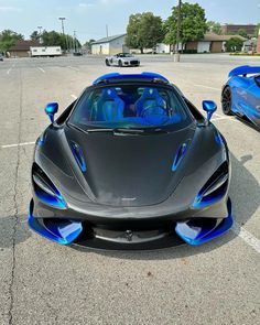 two blue and black sports cars parked in a parking lot