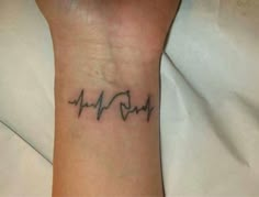 a small wrist tattoo with the word love on it