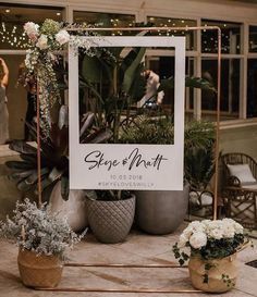 a sign that says sage and north sitting on top of a table with potted plants