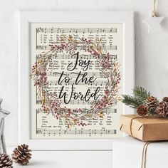 a framed print with the words joy to the world on it next to christmas decorations