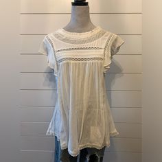 This Is A Relaxed Babydoll Blouse With Lace Detailing, Flutter Sleeves And A Crew Neckline, Back Keyhole With Button Closure, It’s Made From A Lightweight Cotton Fabric. White Babydoll, Babydoll Blouse, Flutter Sleeves, Flutter Sleeve, Crew Neckline, Baby Dolls, Color White, Cotton Fabric, Womens Tops