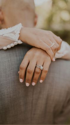 a man and woman holding each other's hands with their wedding rings on them