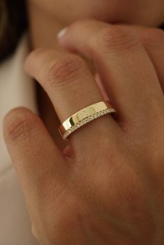 a close up of a person wearing a gold ring with diamonds on the middle finger