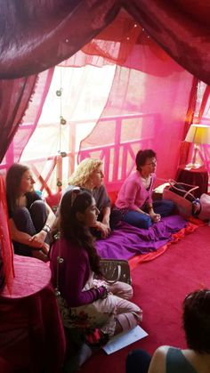 several people sitting on the floor in a tent