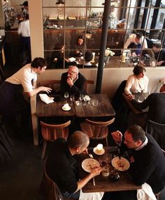 people sitting at tables in a restaurant eating food