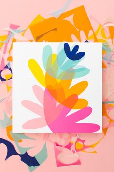 a card with colorful flowers on it and confetti scattered around the card in the background