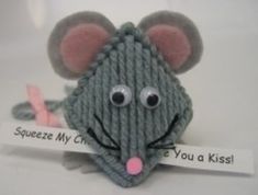 a knitted mouse holding a sign that says squeeze my crochet is you a kiss