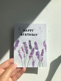 someone holding up a birthday card with lavender flowers