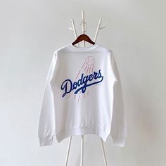 90s Los Angeles Dodgers MLB sweatshirt/ L * PLEASE READ BEFORE PURCHASE * PLEASE consider the PHOTOS before making the decision * The images may DIFFER in appearance from the actual product because we took pictures under daylight.  * PLEASE send your PHONE NUMBER after your purchase for the shipping company to contact you X No returns X No refund Condition : 9/10 More details : look at the pictures  Brand : Tultex Size : L Pit to pit/ Chests : 22.5/45 inches  Length : 26.5 inches  Material : cotton polyester  Color : white * ALL ITEMS are VINTAGE which may show some signs of wear and tear * Due to the different display and different light, the picture may not reflect the actual color of the item * Please, remember that our items are vintage so they may show some signs of wear, tear and yel Throwback Crew Neck Sweatshirt With Logo Print, Throwback Logo Print Sweatshirt For Sports Season, Throwback Sweatshirt With Logo Print For Sports Season, Throwback Logo Print Sweatshirt For Fall, Fall Throwback Logo Print Sweatshirt, Throwback Crew Sweatshirt For Sports Season, Throwback Long Sleeve Letter Print Sweatshirt, College Throwback Style Sweatshirt With Screen Print, Throwback College Sweatshirt With Relaxed Fit