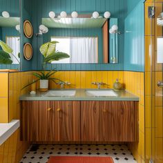 a bathroom with yellow and blue walls, two sinks and a large mirror on the wall