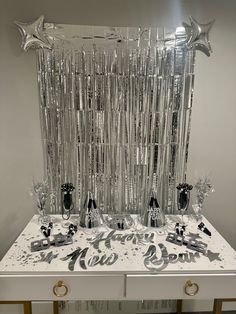 a new year's eve party table with balloons and streamers on the top