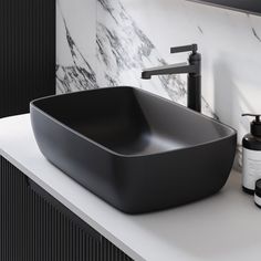 a black bowl sink sitting on top of a counter next to a soap dispenser