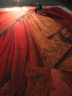 a person is laying on the floor with a red and gold carpet in front of them