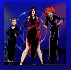 three women dressed in black and red standing on stage with their hands behind their backs