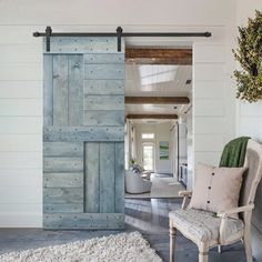 an open door leading to a living room with a chair and rug on the floor