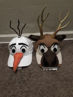 two hats that look like animals with antlers and carrots on their heads are sitting on the floor