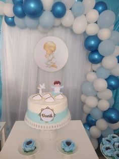 a cake and cupcakes on a table in front of some blue and white balloons