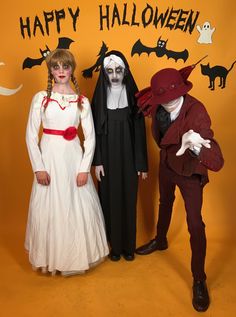 three people in halloween costumes standing next to each other