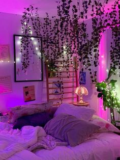 a bed with pillows, blankets and lights in a room that has plants growing on the wall