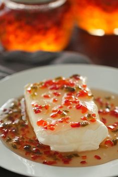 a white plate topped with fish covered in sauce