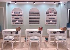 three white tables and chairs in a room with shelves filled with bottles on the wall