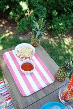 a table topped with bowls of food next to pineapples and watermelon