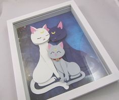 two cats sitting next to each other in a white frame