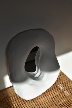 a white sculpture sitting on top of a wooden table