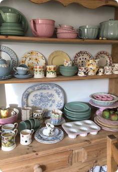 the shelves are filled with plates and bowls