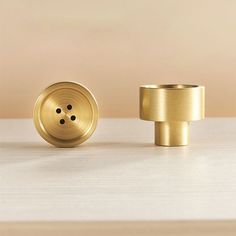 two brass knobs sitting next to each other on a table